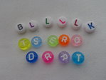 Buchstaben-Perlen, farbig und weiß mit verschieden farbenen Buchstaben